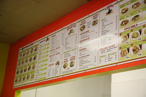 The bright and colorful menu attracts customers into Chuys Taco Shop. There are many different varieties to choose from.