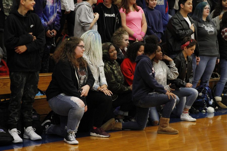Students take a stand by kneeling during the anthem